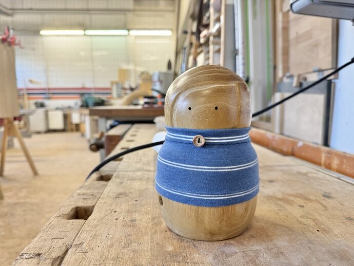 Nachaufnahme einer hölzernen Puppe ohne Gliedmaßen mit blauem Pullover