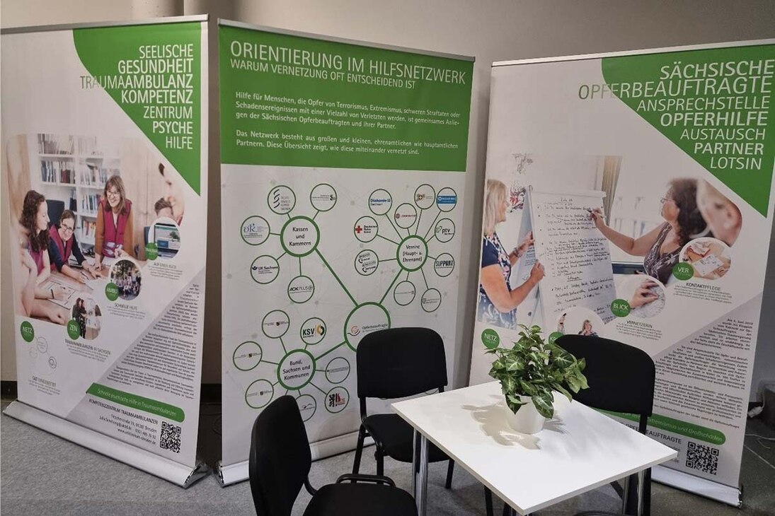 Roll-ups der Wanderausstellung der Sächsischen Opferbeauftragten 2023 auf einer Ausstel-lungsfläche der Messe FLORIAN, einander gereiht mit Texten und Bildern zu Hilfeangeboten für Betroffene.