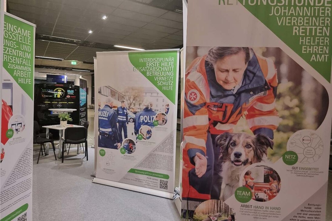 Roll-ups der Wanderausstellung der Sächsischen Opferbeauftragten 2023 auf einer Ausstel-lungsfläche der Messe FLORIAN, einander gereiht mit Texten und Bildern zu Hilfeangeboten für Betroffene.