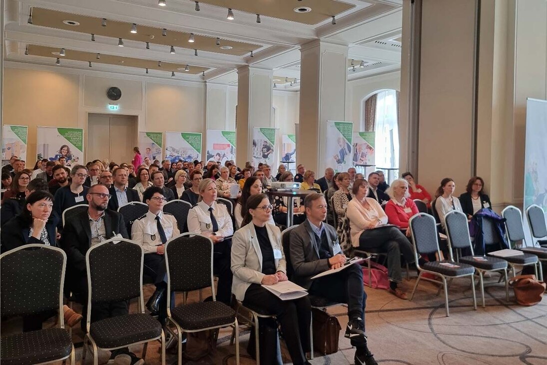 Blick ins Publikum bei einer Netzwerkveranstaltung in einem großen Saal mit vielen Stuhlreihen.