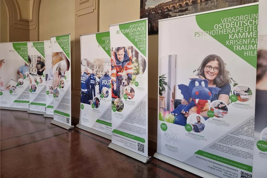 Roll-ups der Wanderausstellung der Sächsischen Opferbeauftragten 2023 im Foyer der Poli-zeidirektion Dresden, einander gereiht vor der Wand, mit Texten und Bildern zu Hilfeangebo-ten für Betroffene.