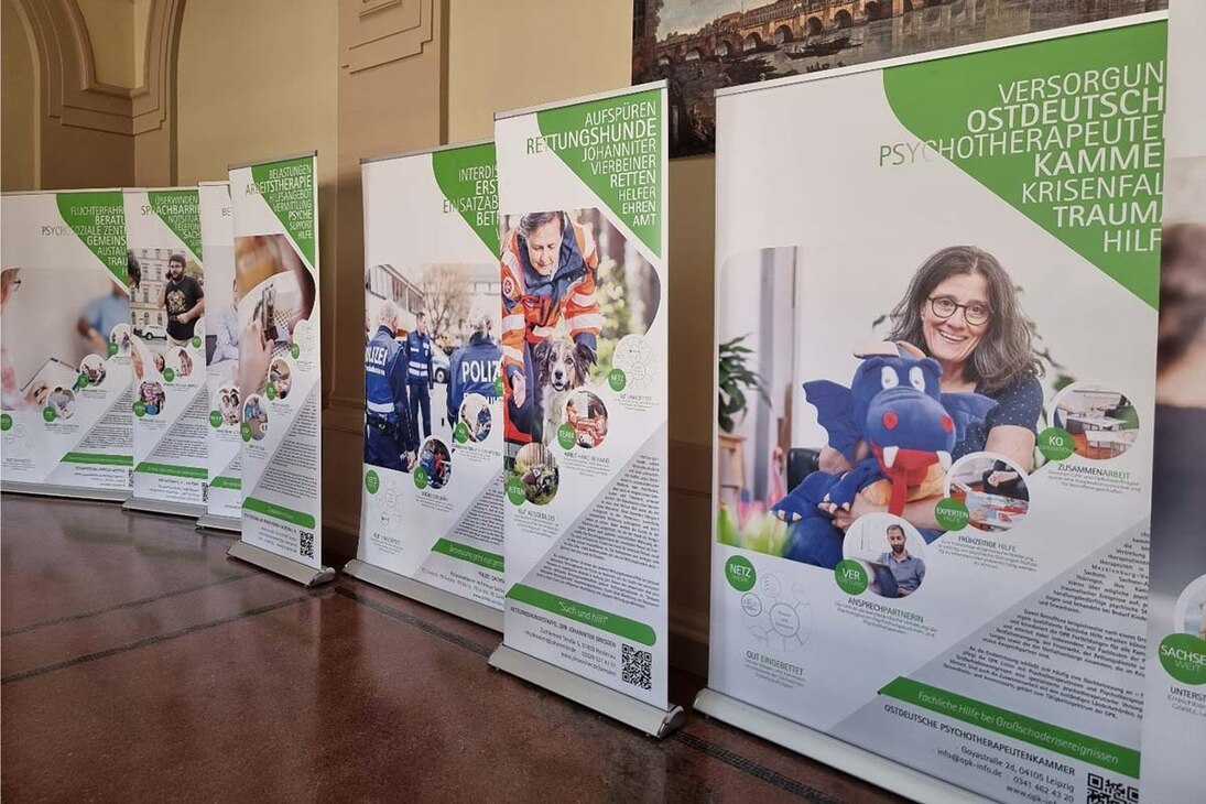 Roll-ups der Wanderausstellung der Sächsischen Opferbeauftragten 2023 im Foyer der Poli-zeidirektion Dresden, einander gereiht vor der Wand, mit Texten und Bildern zu Hilfeangebo-ten für Betroffene.