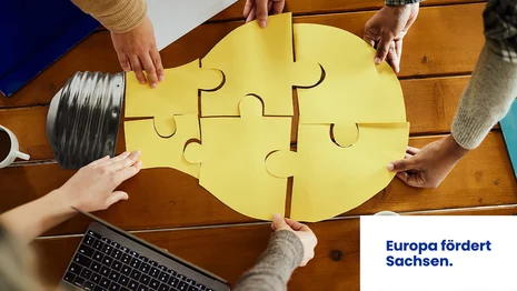 Drei Menschen puzzeln zusammen eine Glühbirne