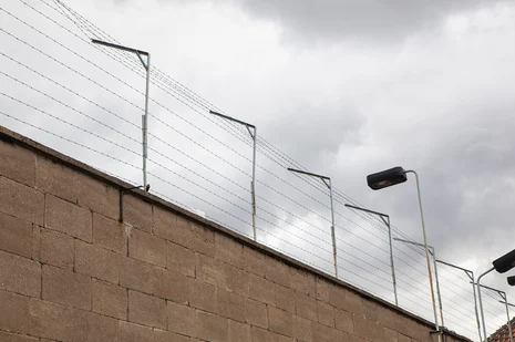 Blick auf die Gefängnismauer mit Stacheldraht des früheren Stasi-Gefängnisses Berlin-Hohenschönhausen