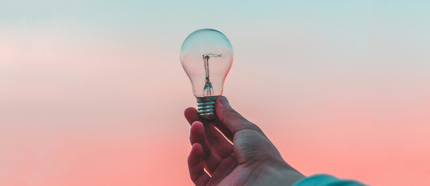 Hand hält Glühbirne in die Höhe